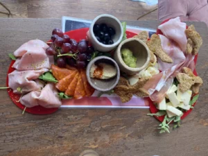 Meat and cheese sharing platter with bread, olives, fruit and dips at Naked Soho.