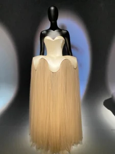 Cream Schiaparelli dress with long fringe displayed at Fashion Becomes Art at the V&A
