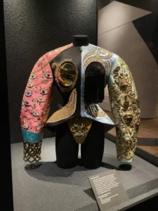 Ornately decorated Schiaparelli jacket displayed at the V&A exhibition