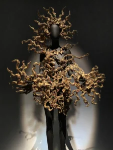 Black Schiaparelli dress with sculptural gold detailing displayed at the V&A